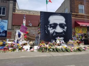 George Floyd Memorial flowers on sidewalk and canvas portrait of Floyd