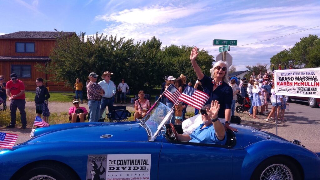 Author Karen McMullin waves to crowd as she serves as Grand Marshal for the Ennis Montana 2025 Fourth of July Parade